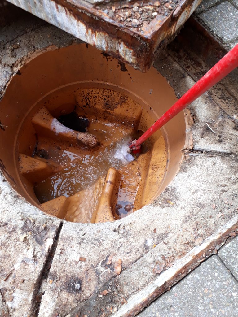 Shallow manhole drain rod to unblock with wet wipes